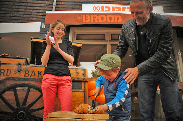 Ties Deen snijdt de eerste BoLoBol onder toeziend oog van papa Fons Deen en Viola van BBROOD (op de achtergrond de bakkerskar) Foto: Shirley Brandeis, 19 mei 2012 