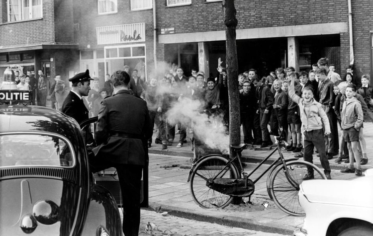 Luilakviering Bos en Lommerplein, 9 juni 1962 Bos en Lommerplein, 9 juni 1962.<br />Luilakviering. Op het Bos en Lommerplein zijn jongens bezig brandje te stichten. De politie is aanwezig om de jongens in toom te houden.9 juni 1962. 