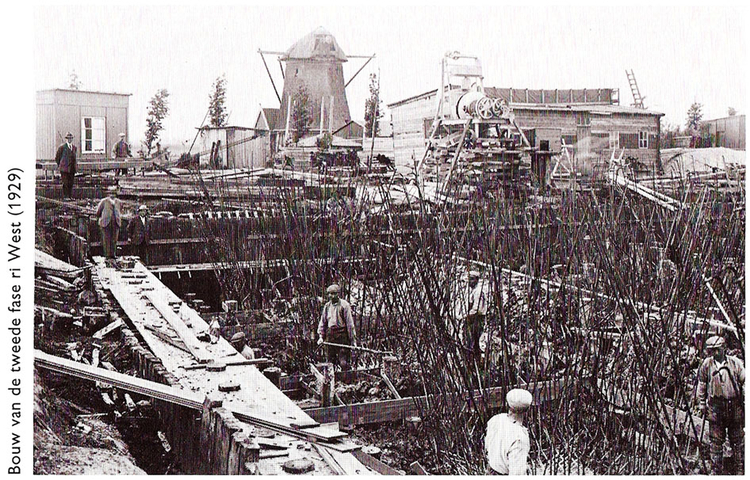 Bouw van de tweede fase rioolwaterzuivering West (1929) met op de achtergrond de molen. Foto: ontleend aan 'Andere tijden, ander afvalwater', een uitgave uit 1993 van de Dienst Riolering en Waterhuishouding Amsterdam (RWA) 