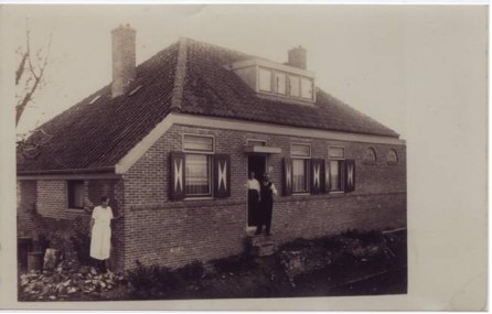 De ‘boerderij’ of woonhuis aan de Haarlemmerweg (C 316 buurt HT). Opa Koek(enbier) met zijn vrouw Laura in de deuropening, links zijn dochter Jo. In dit huis heeft hij gewoond van 1922 tot in 1934. <br /><br />Foto circa 1923, collectie Jan Wiebenga. 