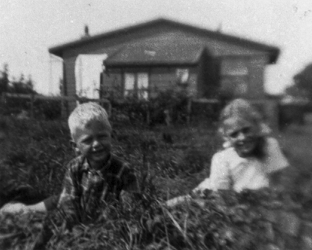 Mijn oudste zus en ik bij de houten woning lang de spoordijk. In 1938 en 1939 kregen we er zusjes bij. Foto: collectie Simon Stammis 