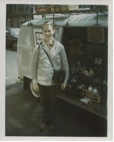 Het prototype van de Amsterdamse melkboer. Licht werkjasje en de leren geldtas gemakkelijk bereikbaar. Jan Hesp naast zijn afgeladen VW-bus in zijn melkwijk. Foto: Jan Hesp, circa 1970 