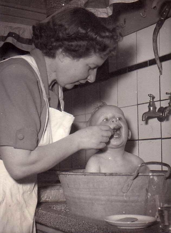 Mijn moeder en ikzelf in de wasteil in de keuken van Postjeskade 189-II Foto: collectie Joost van Ingen 