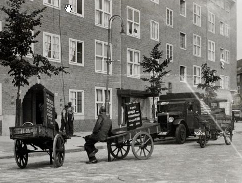 Een voddenkar, kolenmannen met hijstouw, de voddenboer zittend op z'n handkar, de vrachtauto met zakken kolen en de bakkerskar met deksel (v.l.n.r.). Foto: fragment van een foto van de beeldbank van het stadsarchief van de gemeente Amsterdam, 1938. 