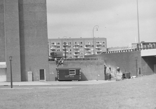 Kinderen op het muurtje bij het nu gesloopte viaduct van de Burgemeester Röellstraat over de Dr. H. Colijnstraat Foto: deel van een foto van de Beeldbank van het Stadsarchief, 1960 