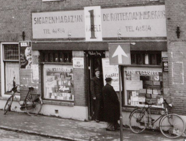 Sigarenmagazijn De Rotterdammerbrug, Eerste Marnixplantsoen nummer 3, hoek Marnixkade, in de deuropening ome Henk Foto: (uitvergroot) circa januari 1956, Stadsarchief Amsterdam. 
