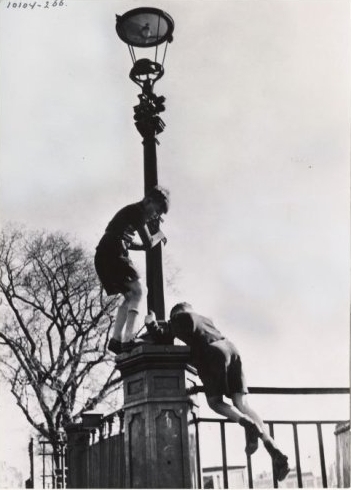 Straatleven: spelende jeugd op een lantaarnpaal, 1950-1955. Bron: beeldbank Stadsarchief Amsterdam 