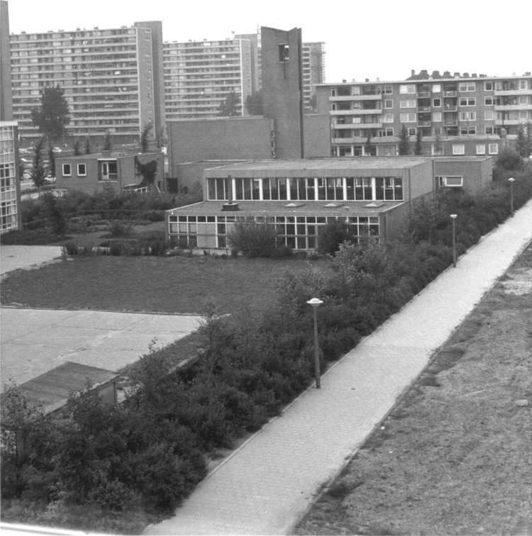 Uitzicht Simonskerkestraat 21-4 Zomer 1969: uitzicht vanuit Simonskerkestraat 21 4-hoog. Met de kerk De Uitweg en de gymnastiekzaal van de Tienhovenschool (foto: André Bos) 